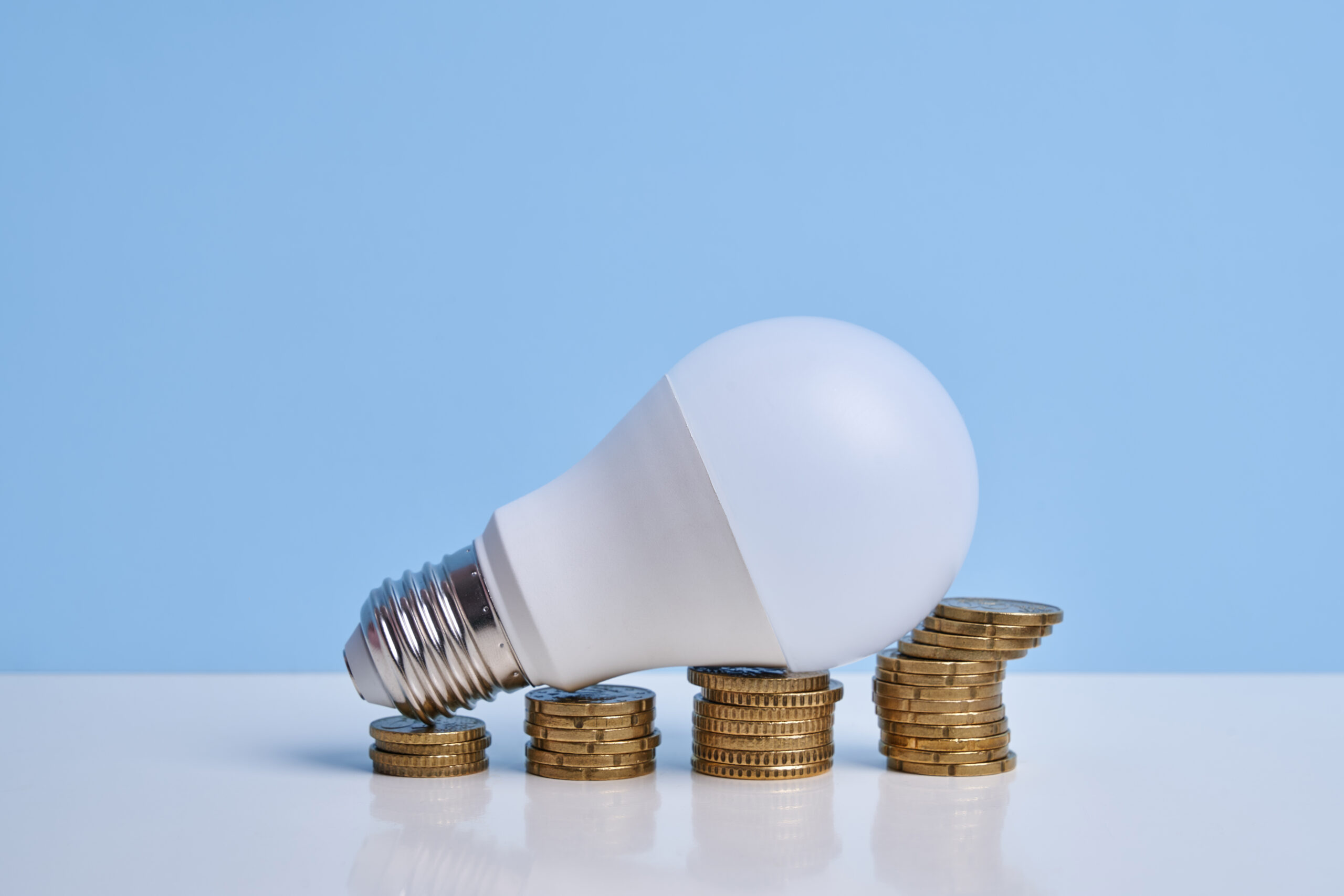 Light Bulb On Stacked Coins Simulating Financial Growth Graph