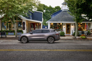 Driver’s side view of 2024 Chevrolet Equinox EV 1LT in Galaxy Gray Metallic parked on a street. Preproduction model shown. Actual production model may vary. Visit chevy.com/EquinoxEV for availability.