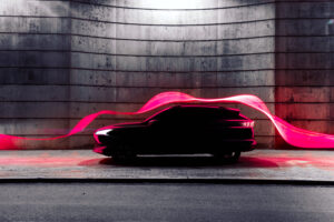 Modern car with futuristic aerodynamic red light trail flowing in cool stage.