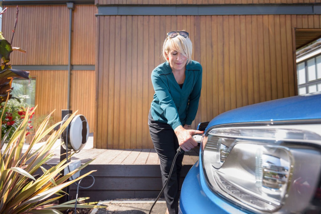 Woman charging electric car from charging point