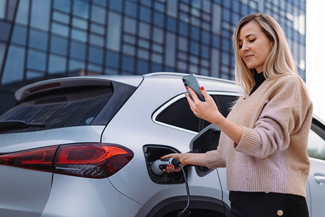 Young woman waiting for car charging.